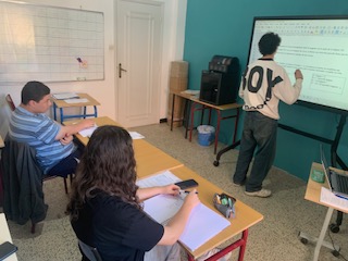 Élèves en cours avec professeur au tableau interactif - Masterclasse Education
